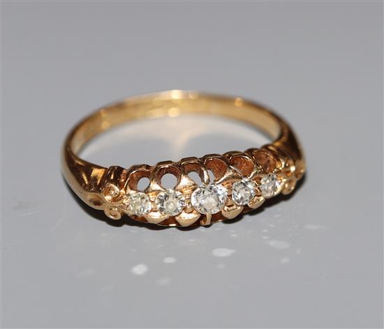 An early 20th century 18ct gold and graduated five stone diamond half hoop ring, size M.